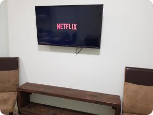 una TV a schermo piatto appesa a un muro con una panca di Petite Palace Rotonda a Salonicco