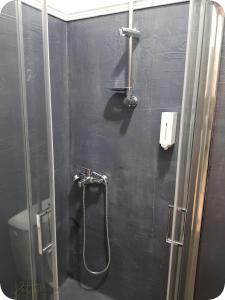 una doccia in bagno con parete nera di Petite Palace Rotonda a Salonicco