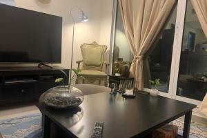 a living room with a table and a tv at All inclusive 1 Bed room apartment - Airport road in Dubai