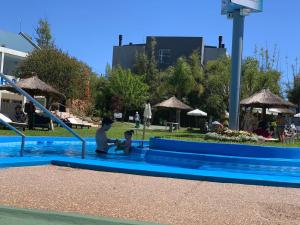 a man and a child sitting in a swimming pool at POSADA SANTA CECILIA in Termas del Daymán