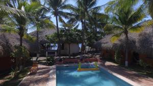 a swimming pool with palm trees and a resort at Dulce y Salado in La Curbina