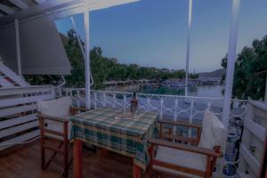 a table and chairs on a balcony with a view of the water at Orfeas Studios in Vasiliki