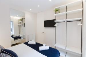 a white bedroom with a bed and a mirror at ATSEGIN apartment climatización -Opción a parking- in San Sebastián