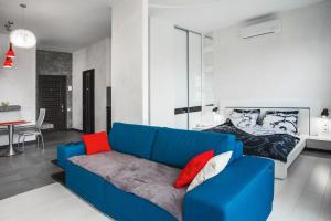 a blue couch in a living room with a bed at Sea View Studio in Arkadia in Odesa