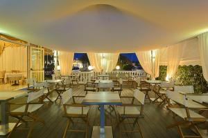 a restaurant with tables and chairs and lights at Hotel Coluccini in Marina di Pietrasanta