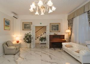 a living room with a couch and a piano at Hotel Coluccini in Marina di Pietrasanta