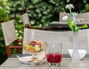 a table with a bowl of fruit and a glass of juice at Hotel Coluccini in Marina di Pietrasanta