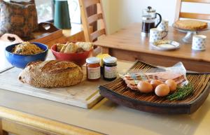 a table with a loaf of bread and eggs on a cutting board at Lavender Farm in Healesville