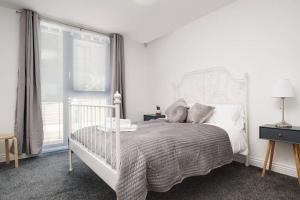 Habitación blanca con cama y ventana en Luxury 2Bed Spacious Apartment- City Centre- Free Parking, en Birmingham