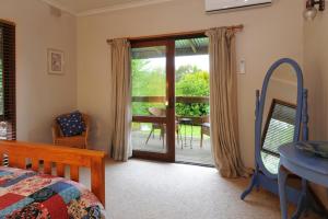 um quarto com uma cama e uma porta de vidro deslizante em Lavender Farm em Healesville