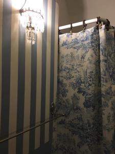 a bathroom with a shower with a blue and white curtain at B&B del Giglio in Cefalù