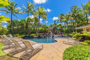 a resort pool with lounge chairs and a gazebo at North Shore Kauai Hideaway condo in Princeville +12 photos