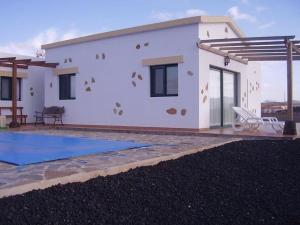 a white house with a mural on the side of it at Villas La Fuentita in Gran Tarajal