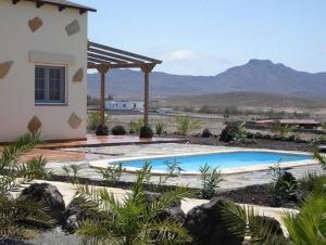 - une piscine en face d'une maison dans l'établissement Villas La Fuentita, à Gran Tarajal