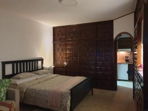 sypialnia z łóżkiem i drewnianą ścianą w obiekcie Madre Tierra Apartment w mieście Puerto de la Madera