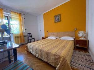 1 dormitorio con cama y pared amarilla en Hvar Guesthouse - Double bedroom with private bathroom, en Jelsa