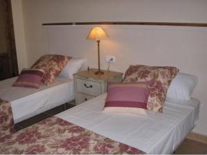 1 dormitorio con 2 camas y mesita de noche con lámpara en Villas La Fuentita en Gran Tarajal
