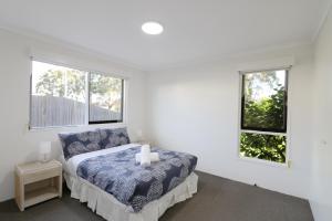 A bed or beds in a room at Pelican Waters