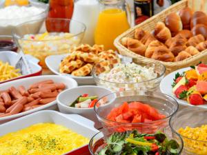 a table topped with bowls of different types of food at HOTEL MYSTAYS Hiroshima Peace Park in Hiroshima