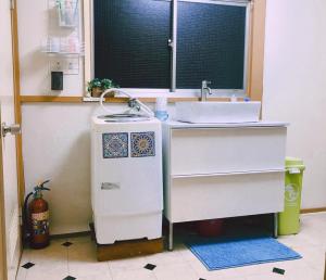 uma cozinha com um lavatório e um aquecedor de água em 世田谷 大晶家 direct to Shinjuku for 13min 上北沢3分 近涉谷新宿 em Tóquio