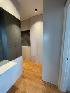 a room with white cabinets and a wooden floor at Pupin Palace Apartments in Novi Sad