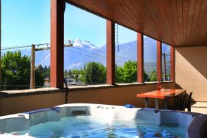 a hot tub on a balcony with a table and mountains at Lily glacier suite at silver bear condos in Revelstoke