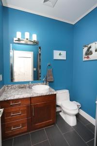 a blue bathroom with a toilet and a sink at Lily glacier suite at silver bear condos in Revelstoke +17 photos