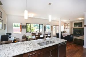 a kitchen with a sink and a living room at Lily glacier suite at silver bear condos in Revelstoke
