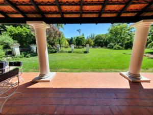 a porch with a brick floor and white columns at La Diferencia in Chivilcoy
