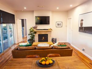 a living room with a couch and a fireplace at Fig Tree Luxury Guest House in Pokolbin