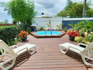 un patio con 2 sillas y una piscina en Villa de 2 chambres avec vue sur la mer piscine privee et jacuzzi a Bouillante, en Bouillante