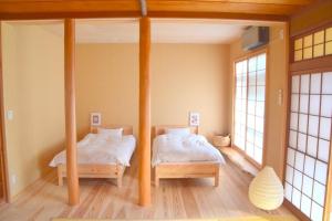 two beds in a room with two windows at Hiyorian - Vacation STAY 11234 in Takamatsu