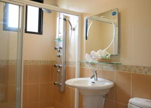 y baño con lavabo y ducha con espejo. en My House Homestay, en Dongshan