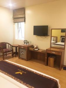 a living room with a television and a mirror at My Iris Hotel in Hanoi