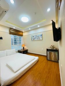 a bedroom with a large bed and a flat screen tv at Good For You Hotel in Ho Chi Minh City