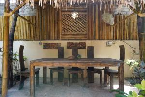 a wooden table and chairs in a room at Puri Hondje in Gili Trawangan