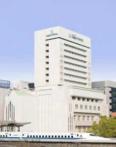 a white building with a train in front of it at Shin Yokohama Grace Hotel in Yokohama