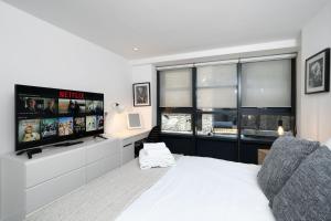 a bedroom with a bed and a flat screen tv at DUPLEX 2 Bedr, 3 Beds, 2,5 Bath Trafalgar Square in London