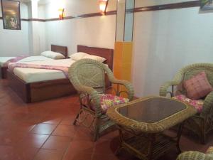 a bedroom with a bed and two chairs and a table at Javier Guesthouse in Tbeng Meanchey