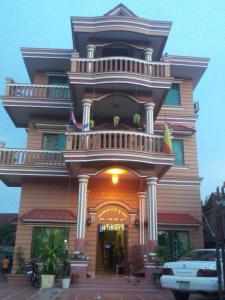 um grande edifício com uma varanda ao lado em Javier Guesthouse em Tbeng Meanchey