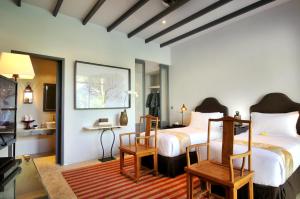 a bedroom with two beds and a table and chairs at Room & Vespa 1 in Seminyak