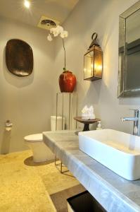 a bathroom with a sink and an apple on the wall at Room & Vespa 1 in Seminyak