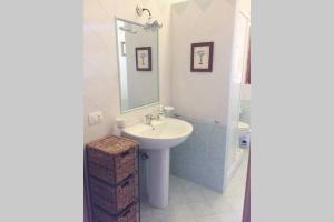 a white bathroom with a sink and a mirror at Villa dei Pioppi in Fontane Bianche +39 photos