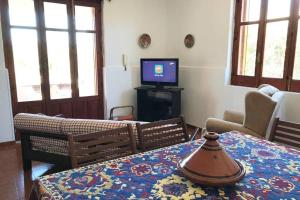 a living room with a table and a tv at Villa dei Pioppi in Fontane Bianche