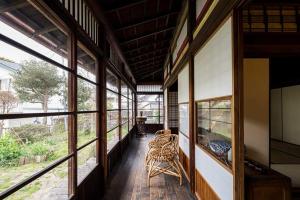 um corredor de uma casa com janelas e cadeiras em 平野邸 Hayama em Hayama