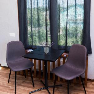 a table and two chairs in front of a window at Golden park Apartments in Uman