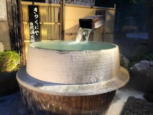 een fontein in het midden van een tuin bij Kinokuniya Ryokan in Hakone