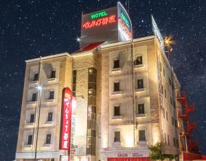 a building with a sign on the top of it at Hotel Benkyo Beya Amagasaki in Amagasaki