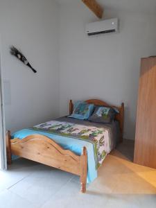- une chambre avec un lit en bois dans l'établissement Maisonnette U Santu Ghjuvandria ou A Santa Ghjulia entre mer et Montagne, à Volpajola