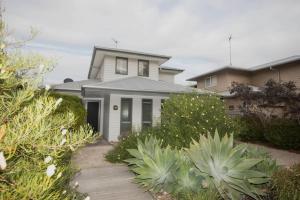 a white house with a porch and some plants at FLINDER's REST in Queenscliff